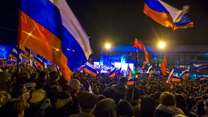Rakyat merayakan kemenangan saat mereka menunggu pengumuman hasil awal referendum hari ini di Lenin Square di ibukota Krimea Simferopol 16 Maret 2014 (Reuters / Thomas Peter)