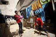 Mohammed al-Faramawi, 15, (L) plays with his brother Jamil, 4, outside their home