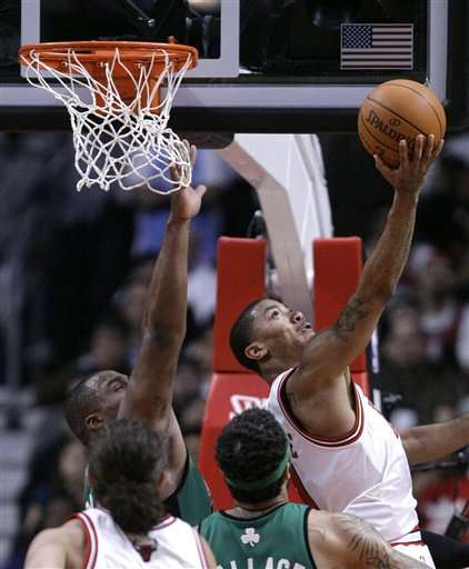 Chicago Bulls guard Derrick Rose, right, shoots a reverse layup past the outstretched arm of Boston Celtics forward Glen Davis, left, as Joakim Noah and Rasheed Wallace watch during the first half of an NBA basketball game Tuesday, April 13, 2010, in Chicago.
