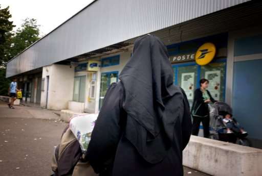 A Muslim woman wearing traditional clothing shops in Venissieux, near Lyon