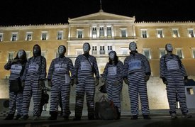 Protesters dressed as prisoners gather during an event to protest against austerity measures outside the Greek parliament in Athens, Tuesday, Nov. 1, 2011.