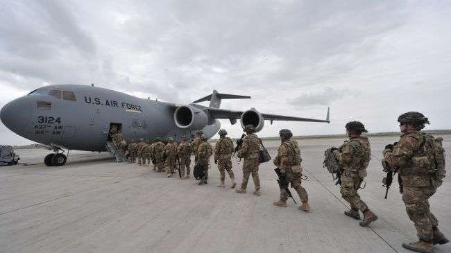 US forces line up to board a military plane at the Manas airbase near the Kyrgyz capital city of Bishkek, April 15, 2011.