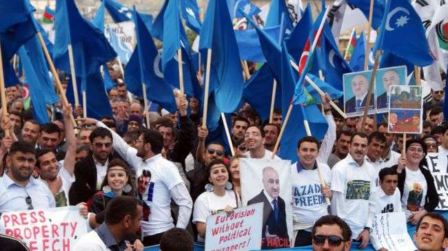 Azerbaijani opposition supporters hold posters and flags during a protest rally in Baku, April 22, 2012.