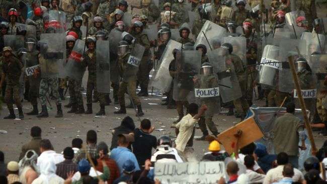 Egyptian demonstrators confront riot police during protests outside the defense ministry in Cairo