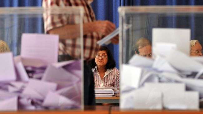 Members of the voting committee are seen behind ballots at a polling station on May 6, 2012, in Belgrade.