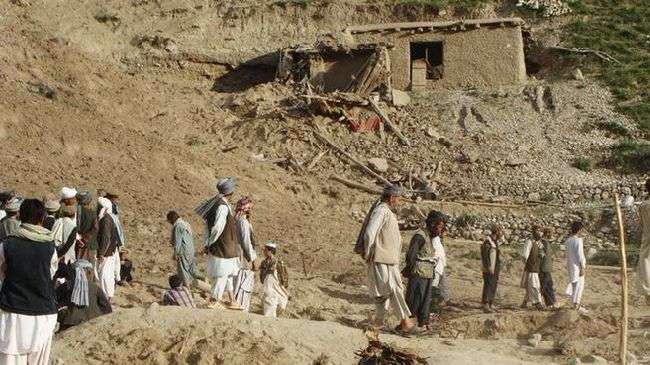 Afghans scramble through rubble in Mullah Jan village, Baghlan province, following the landslide trigged by earthquakes on June 11, 2012.