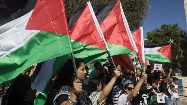 Palestinians wave national flags during a rally against Israeli occupation on June 5, 2012.