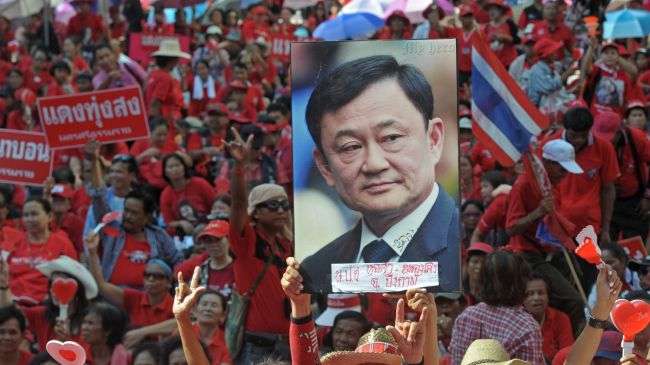 "Red Shirt" supporters hold a picture of fugitive former Premier Thaksin Shinawatra during a demonstration to mark the second anniversary of a deadly crackdown on street protests in Bangkok on May 19, 2012.