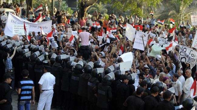 Egyptian riot police stand guard as demonstrators protest against the visit of US Secretary of State Hillary Clinton outside the US embassy in Cairo on July 14, 2012.