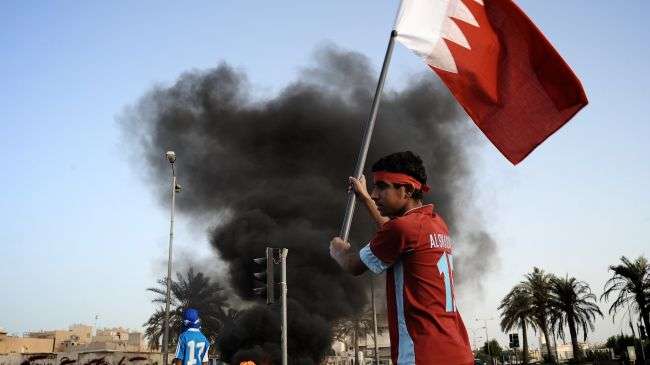 A Bahraini protester waves his national flag during a demonstration in solidarity with jailed dissident Abdel Hadi Khawaja and prominent rights activist Nabeel Rajab in the village of Daih, west of Manama on June 11, 2012.