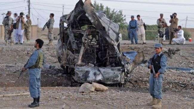 Afghan soldiers stand guard near the site of a car bomb attack in Kandahar city on July 2, 2012.