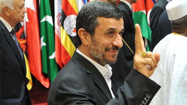 Iranian President Mahmoud Ahmadinejad flashes the V-sign as he attends an extraordinary summit of the Organization of the Islamic Cooperation (OIC) in Mecca, August 14, 2012.