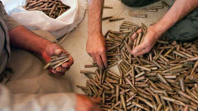 Insurgents from the so-called Free Syrian Army take AK-47 bullets from a weapons dealer in Idlib Province.