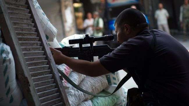 A member of the foreign-backed Free Syrian Army (FSA) takes aims with a sniper rifle at a checkpoint in the northern city of Aleppo on August 20, 2012.