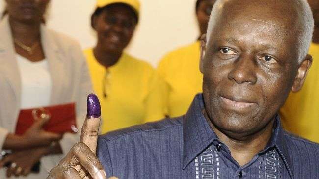 Angolan President Jose Eduardo dos Santos shows his ink marked finger after casting his ballot on August 31, 2012.