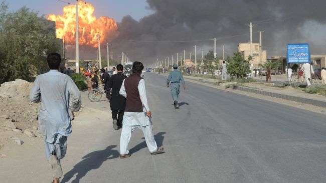 Afghan bystanders react following an explosion at a fuel warehouse in Kabul on July 4, 2012.