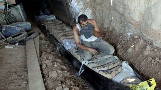 Palestinian men transport bags of cement through tunnels used for smuggling goods, including food, fuel, and building materials, along the Gaza-Egypt border in Rafah in the southern Gaza Strip on August 23, 2012.