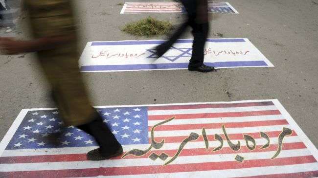 Pakistani demonstrators walk over the flags of the US and the Israeli regime as they march toward the US embassy during a demonstration against an anti-Islam film in Islamabad, September 14, 2012.