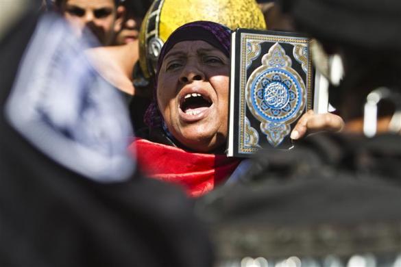 A Palestinian woman shouts as she hold a Quran during demonstrations denouncing a U.S.-made film that mocks the Prophet Mohammed after Friday prayers near Damascus Gate outside Jerusalem Old City September 14 2012. Israeli police some on horseback used s