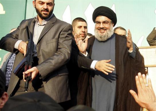 Lebanon Hezbollah leader Sayyed Hassan Nasrallah (R) escorted by his bodyguards makes a rare public appearance as he greets his supporters at an anti-U.S. protest in Beirut southern suburbs September 17 2012.