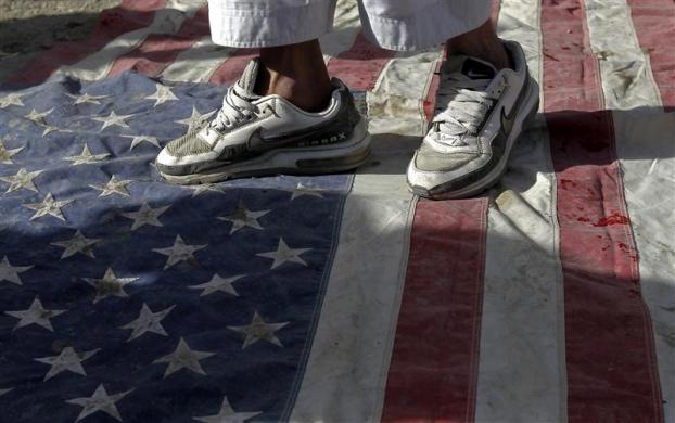 An Afghan protester steps on a U.S. flag during a demonstration in Kabul September 21 2012. Hundreds of Afghans protested against a U.S.-made film they say insults the Prophet Mohammad.
