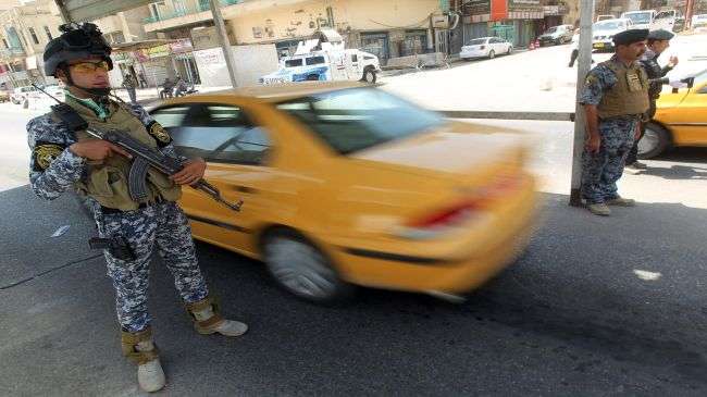 Iraqi police forces stand guard at a checkpoint in central Baghdad on July 24, 2012.
