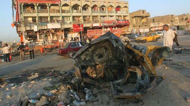 Iraqis inspect on August 17, 2012 the aftermath of a car bomb which exploded the previous night in Baghdad.
