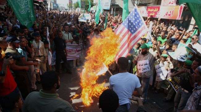 Palestinian men burn the US flag during a protest against a film mocking Islam, in Rafah, southern Gaza Strip, on September 14, 2012.