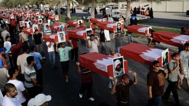Bahraini demonstrators in a village near Manama carry symbolic coffins with pictures of people killed by regime forces.