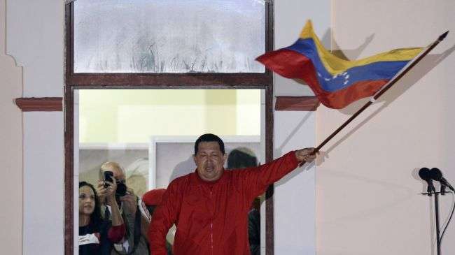 Venezuelan President Hugo Chavez waves his country’s flag while speaking to supporters after receiving news of his reelection, Caracas, October 7, 2012