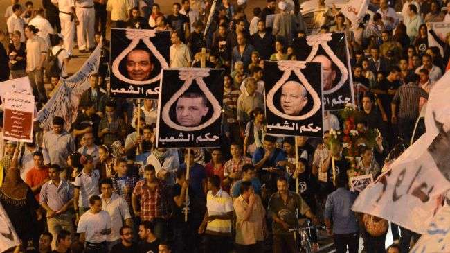 Egyptian protesters hold portraits of members of the former military council as they march in Cairo on October 9, 2012.