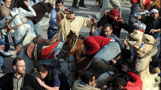 A picture taken on February 2, 2011 shows supporters of ousted Egyptian dictator Hosni Mubarak on horses and a camel, clashing with anti-regime protesters in Cairo.
