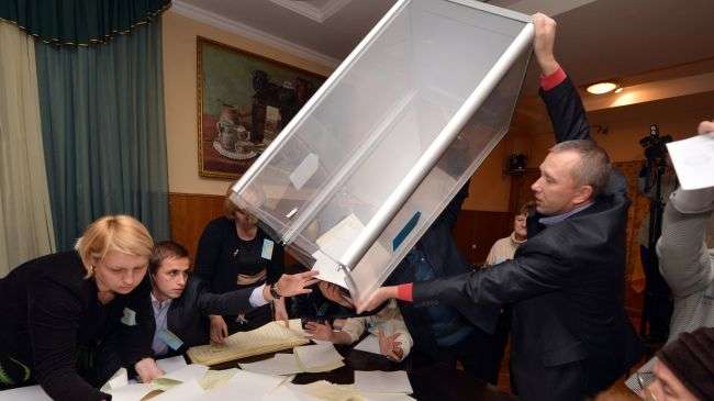 Election commission members empty a booth to count ballots after national parliamentary elections in Kiev on October 28, 2012.