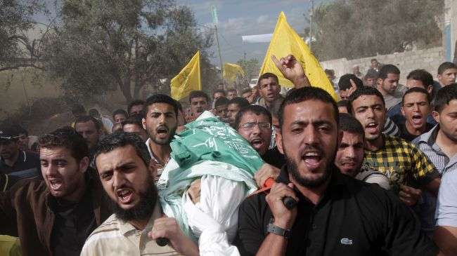 Palestinians carry the body of 13-year-old Humeid Yunis Abu Daqqah, who was killed after being hit by bullets fired from an Israeli helicopter, November 9, 2012.