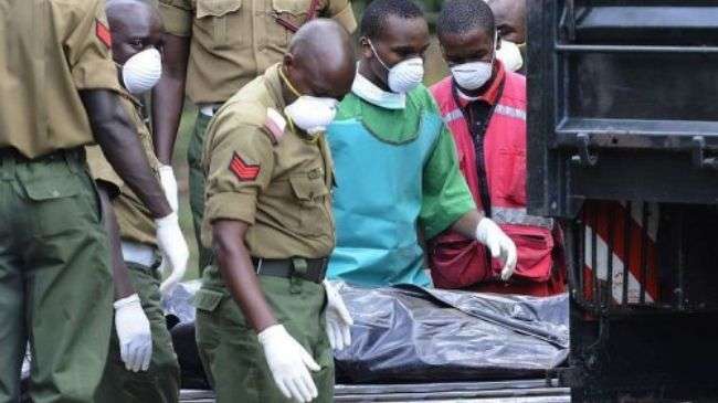 A morgue attendant in the Kenyan capital, Nairobi, moves the body of one of the 42 policemen killed on November 10, 2012.