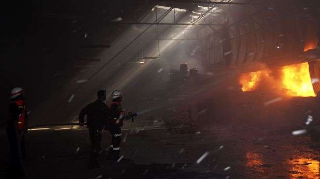 Palestinian firefighters try to extinguish fire at a factory, which was hit by an Israeli air strike in Beit Lahia, northern Gaza Strip, on November 16, 2012.