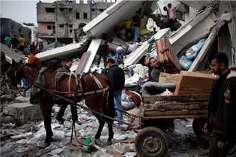Palestinians load their belongings onto a horse cart after an airstrike on a house in Gaza City Nov. 18, 2012.