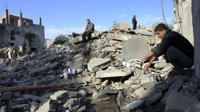 Palestinians look at their destroyed homes following Israeli air strikes on the southern Gaza Strip town of Rafah on November 18, 2012.