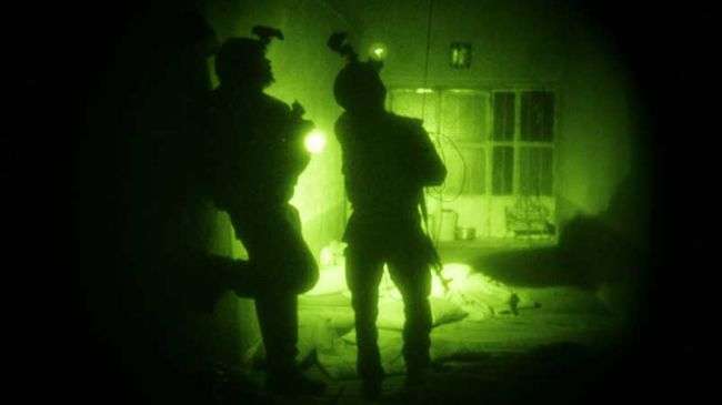 US Special Operations forces search a home during a nighttime raid in Afghanistan.