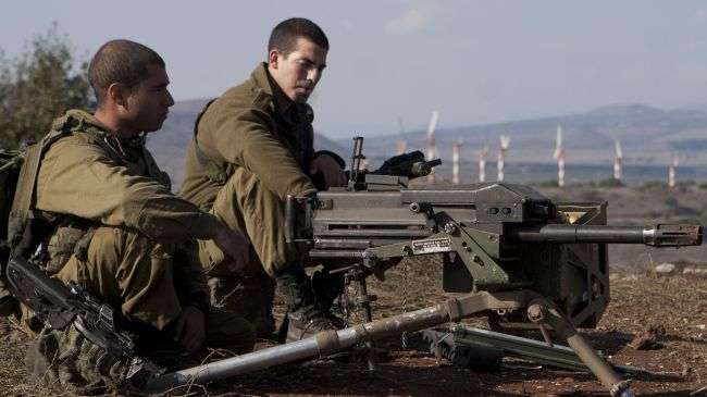 Israeli soldiers sit in an abandoned military outpost in the occupied Golan Heights on November 15, 2012.