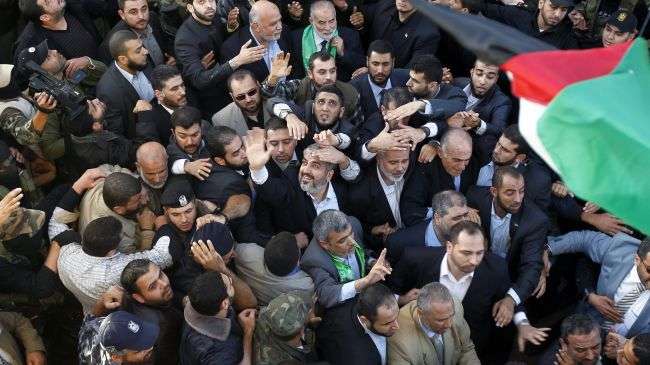 Hamas Political Bureau Chief Khaled Meshaal (center waving) greets Palestinians upon arrival in Gaza City on December 7, 2012.