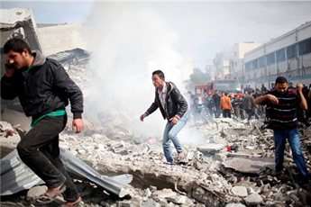 Palestinians run after an Israeli air strike on a house in Gaza City Nov. 18, 2012.