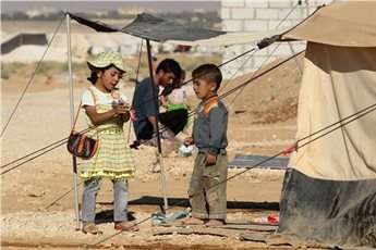 Syrian refugee children play with toys from humanitarian organizations at al-Zaatri refugee camp in the Jordanian city of Mafraq.