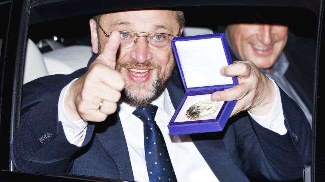 European Parliament President Martin Schulz displays the Nobel medal as he leaves the Grand Hotel by car after the Nobel Banquet a dinner following the Nobel Peace Prize ceremony, December 10, 2012.