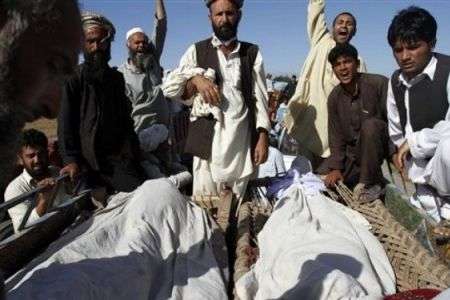 Afghans gather around the bodies of people killed by US-led foreign forces.