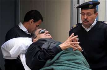 Former Egyptian president Hosni Mubarak lies on a gurney bed while leaving the courtroom at the police academy, during his trial in Cairo in January.