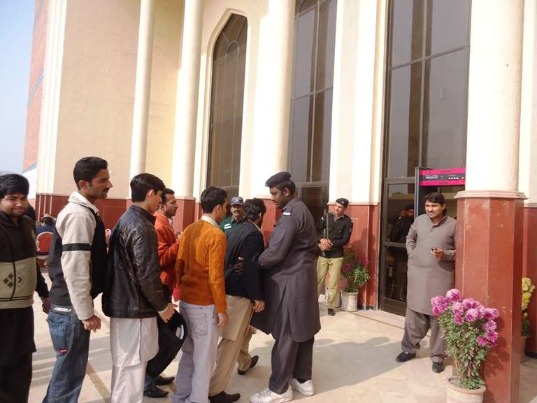جناح میں آڈیٹوریم میں داخل ہونے کے لیے طلباء سکیورٹی کے مرحلے سے گذررہے ہیں