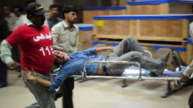 Pakistani volunteers carry an injured blast victim into a hospital in Karachi, November 21, 2012.