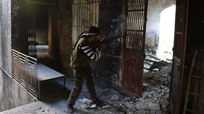 A Syrian rebel shoots at government forces in the northwestern city of Aleppo on November 15, 2012.