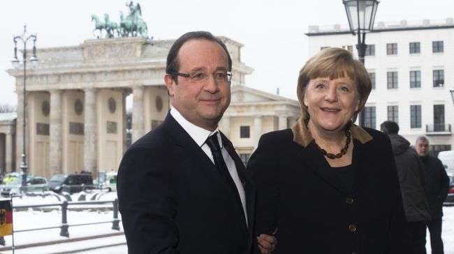 French President Francois Hollande (L) welcomes German Chancellor Angela Merkel in front of the Brandenburg Gate near the French Embassy in Berlin on January 22, 2013.